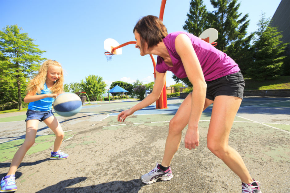 A mother play basketball with his daughter